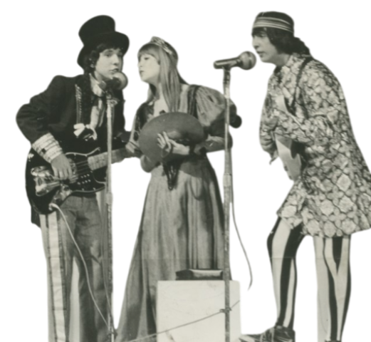 A imagem apresenta o grupo musical Os mutantes, sao tres pessoas cantando em um microfone